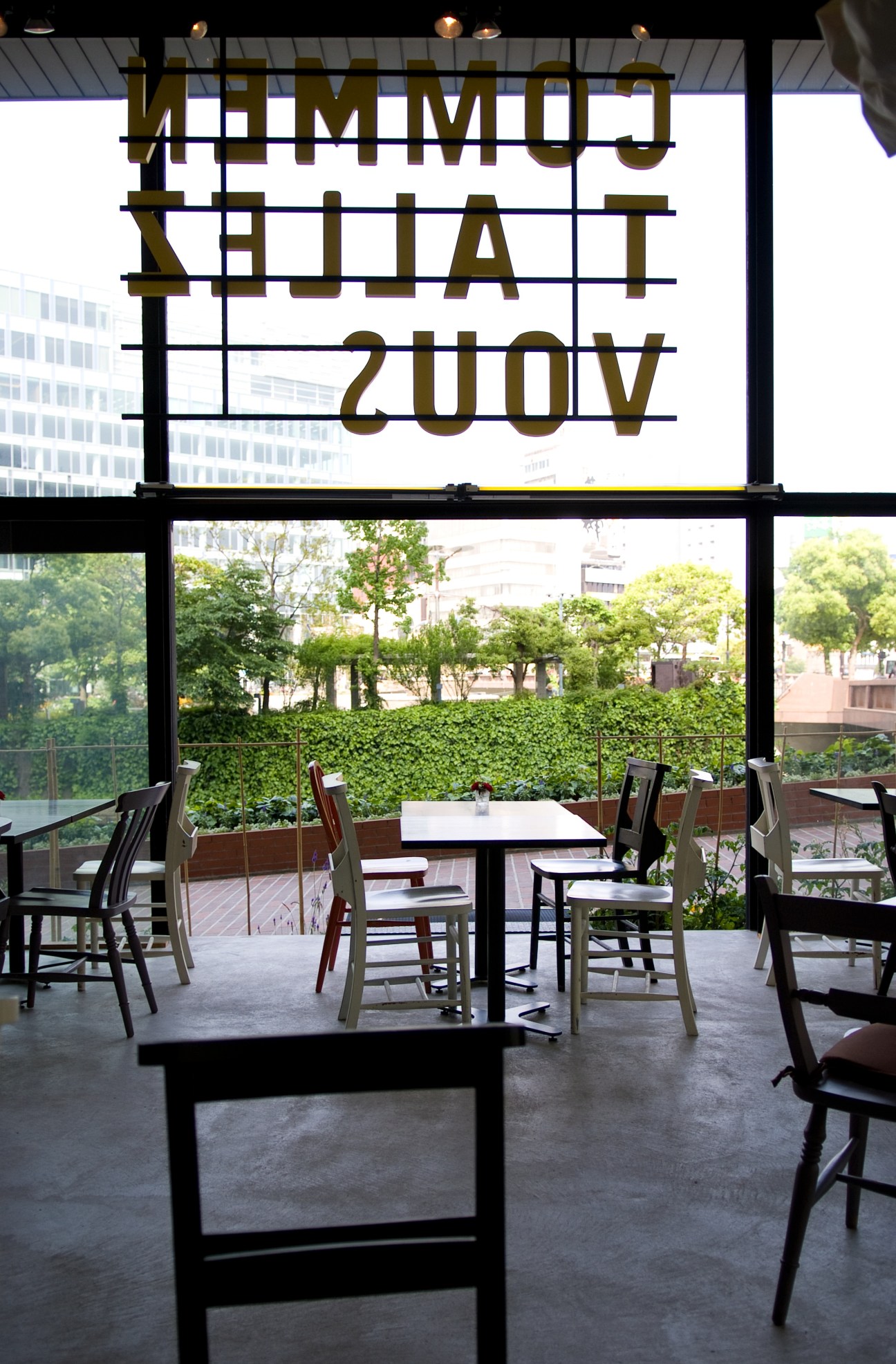 Comment Allez Vous café and bar interior with neon signage and outdoor terrace seating