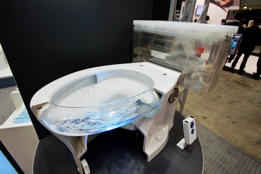 Toilet bowl demonstration showing water swirling during a tornado flush cycle at Toilet Tokyo convention.