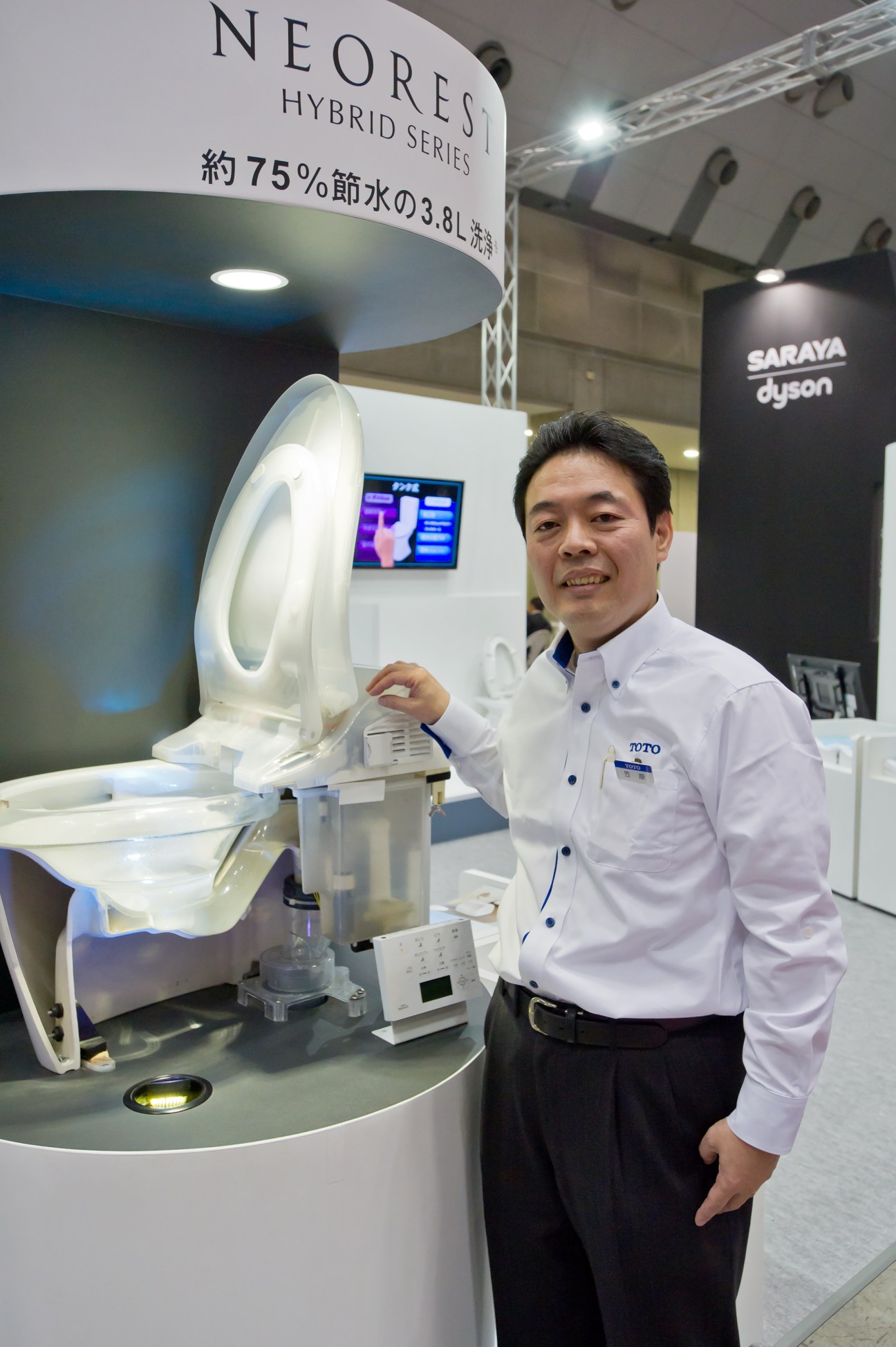Toto employee demonstrates the Neorest hi-tech toilet with digital display at Toilet Tokyo convention.