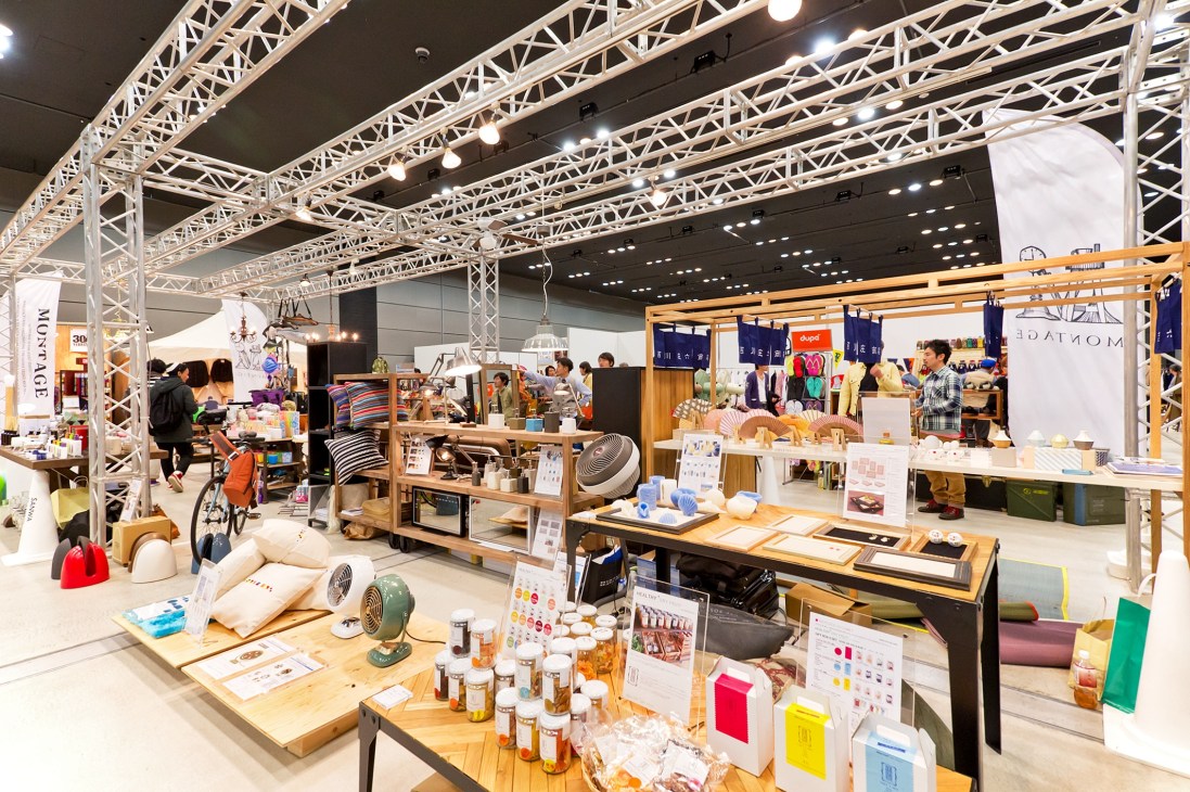 Interior view of Jumble Tokyo trade show in Shibuya with multiple vendor booths displaying fashion and accessories under industrial lighting.