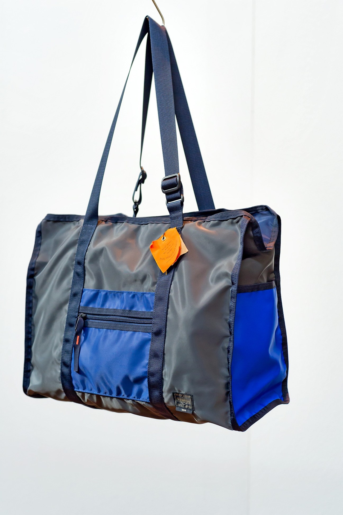 Bag from Minotaur featuring grey and blue technical fabric with navy straps and orange accent tag.