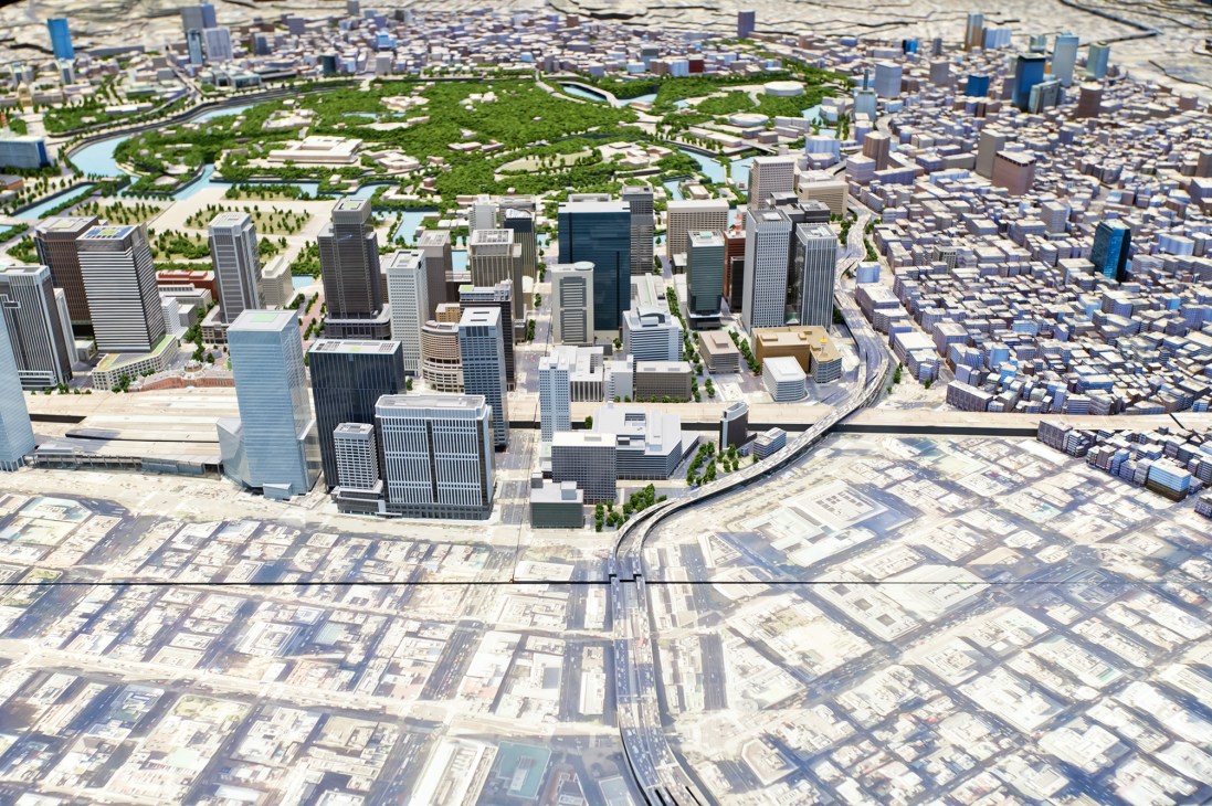 Aerial model of Tokyo's Marunouchi district showing modern towers, green spaces and the Imperial Palace moat.