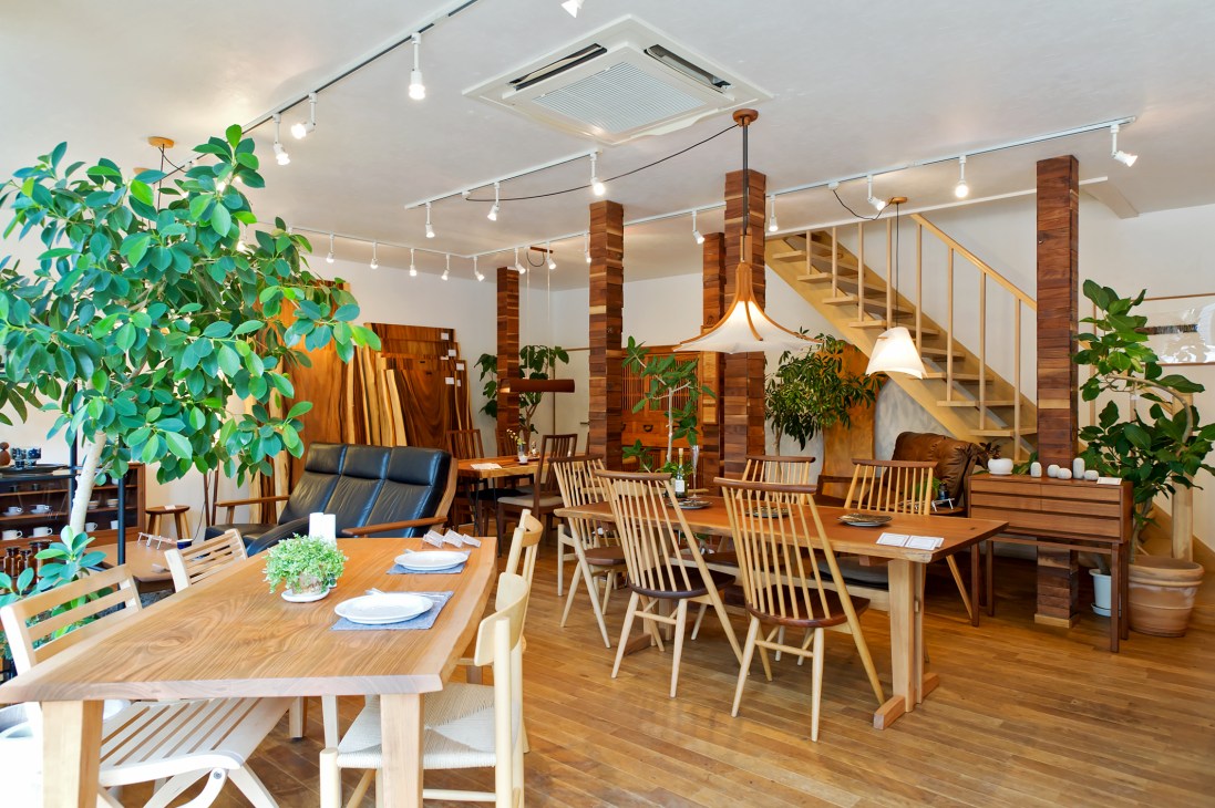 Interior of Brunch + Time furniture showroom with wooden tables, chairs, and pendant lighting.