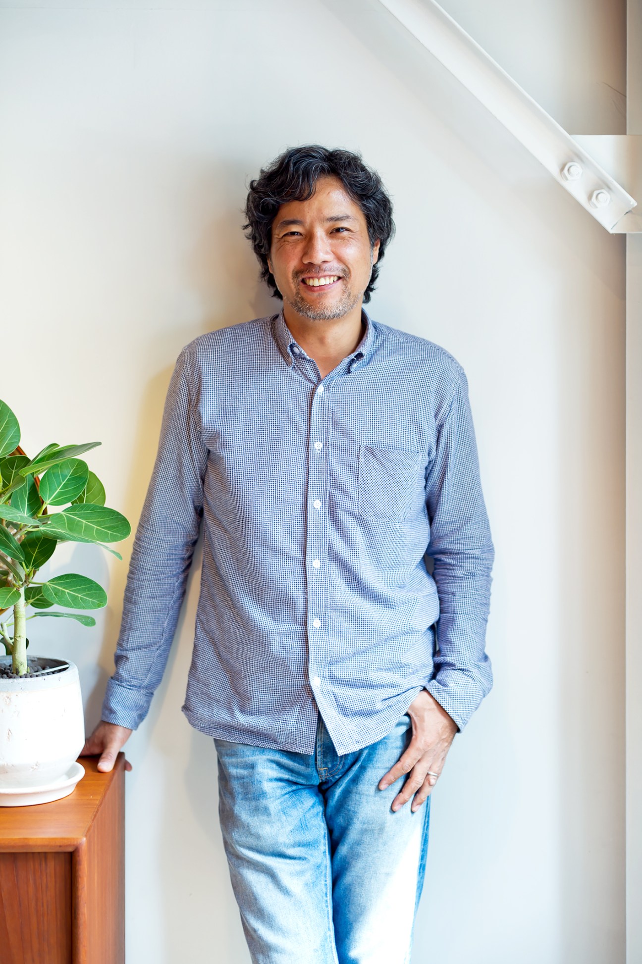 Kosuke Ebira, owner of Lewis furniture shop, smiling at camera in casual blue shirt