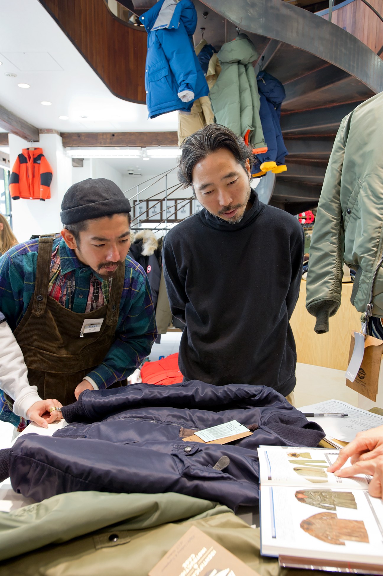 Beams staff examine vintage aviation jackets during a styling training session at the store.