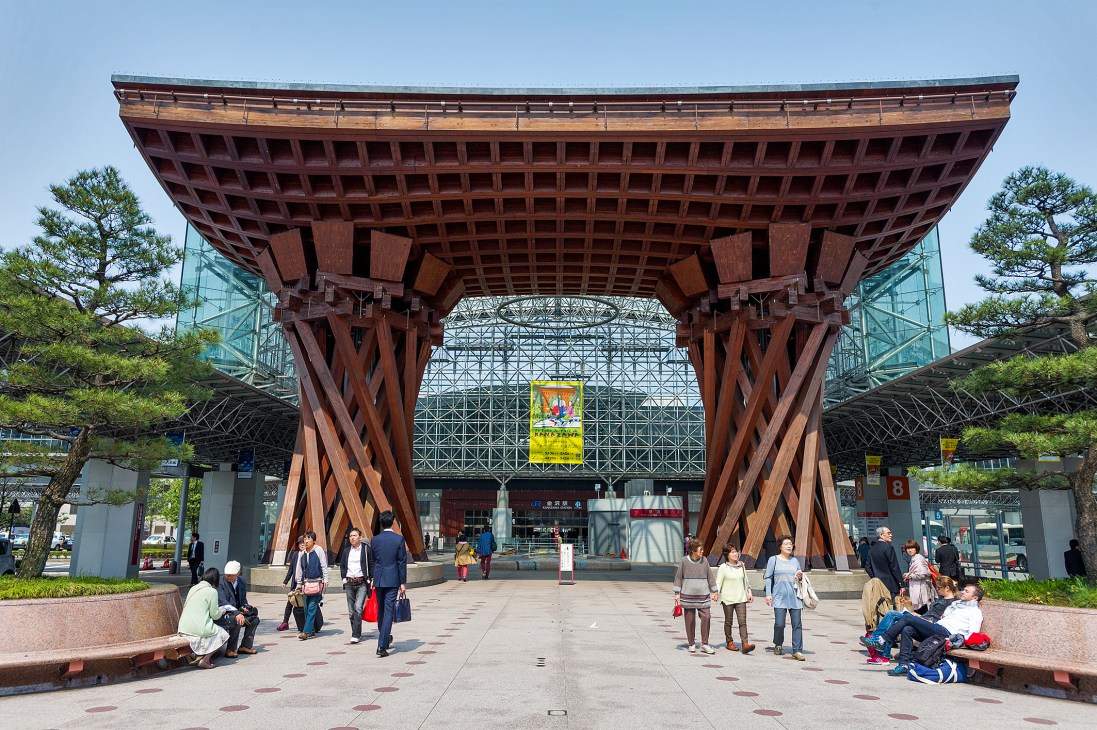 Tsuzumi Gate at Kanazawa Station, a large traditional wooden structure with curved roof and modern glass architecture behind it.