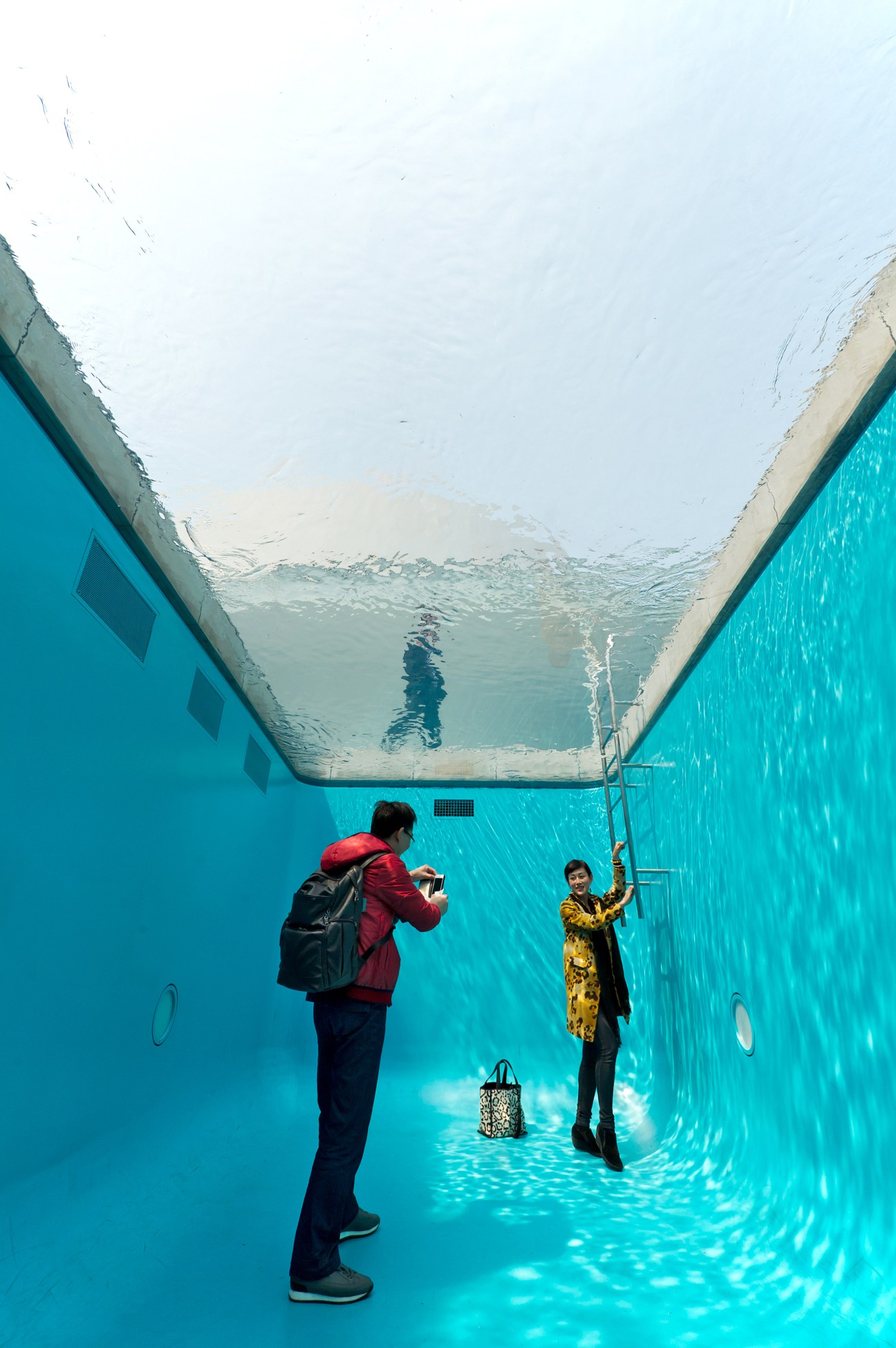 Visitors inside 'The Swimming Pool' installation at 21st Century Museum of Contemporary Art in Kanazawa.