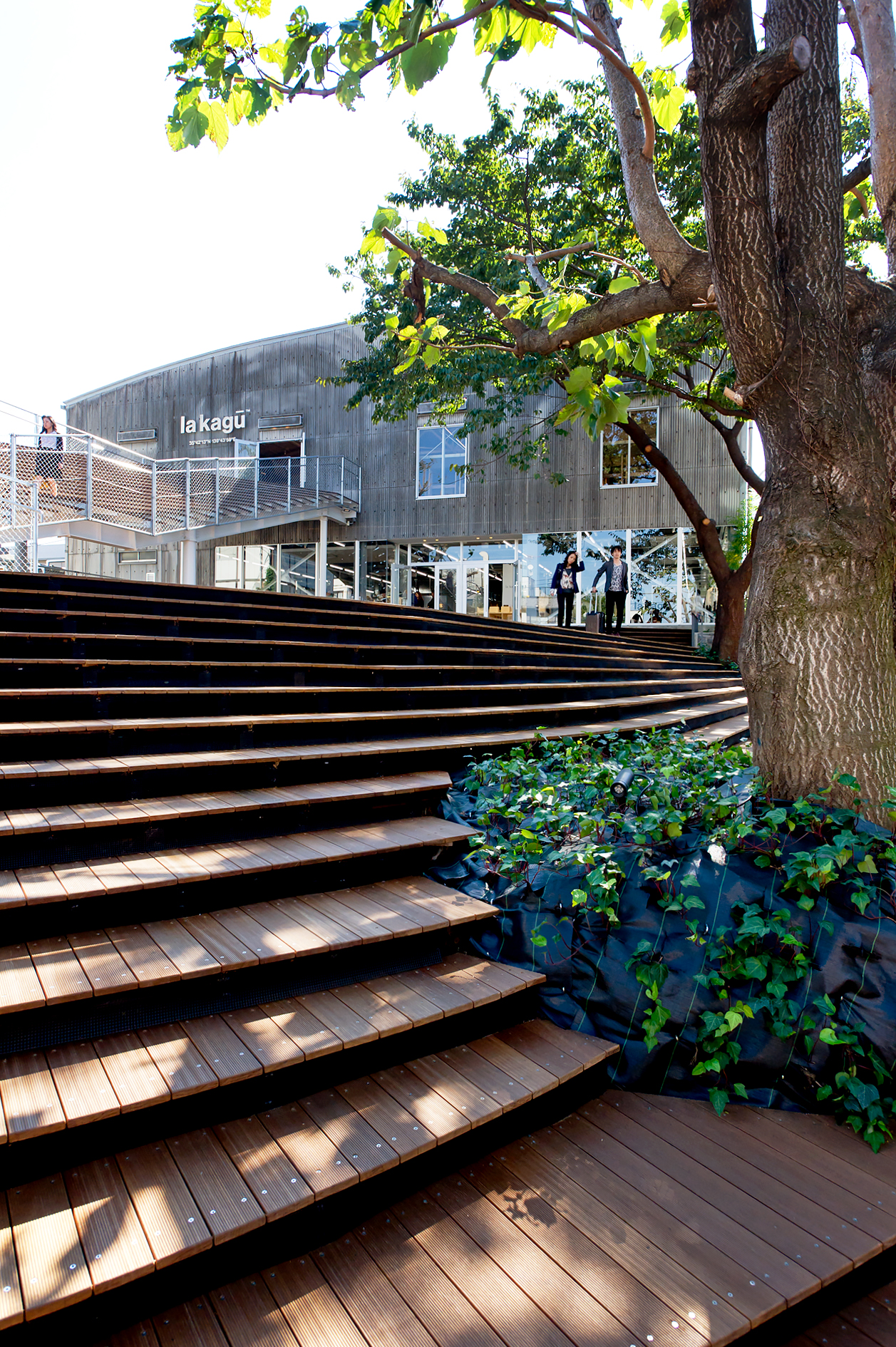 La Kagu's wooden deck with metal stairs leading to the corrugated-steel warehouse building in Tokyo.
