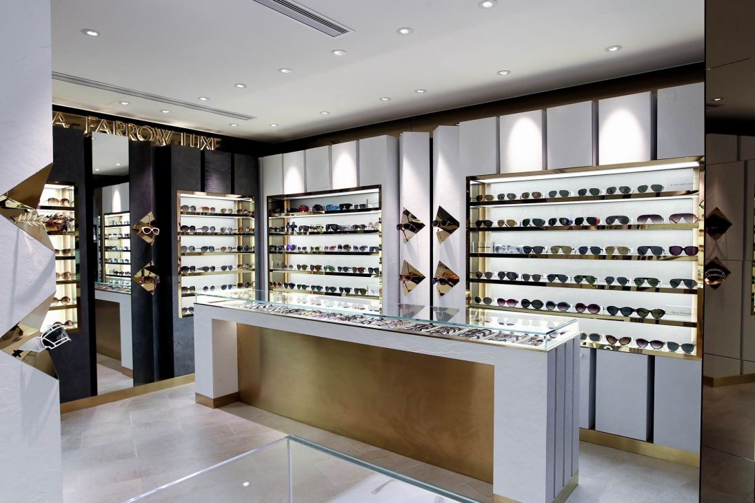 Interior of Linda Farrow eyewear store with illuminated display shelves showcasing sunglasses and frames.