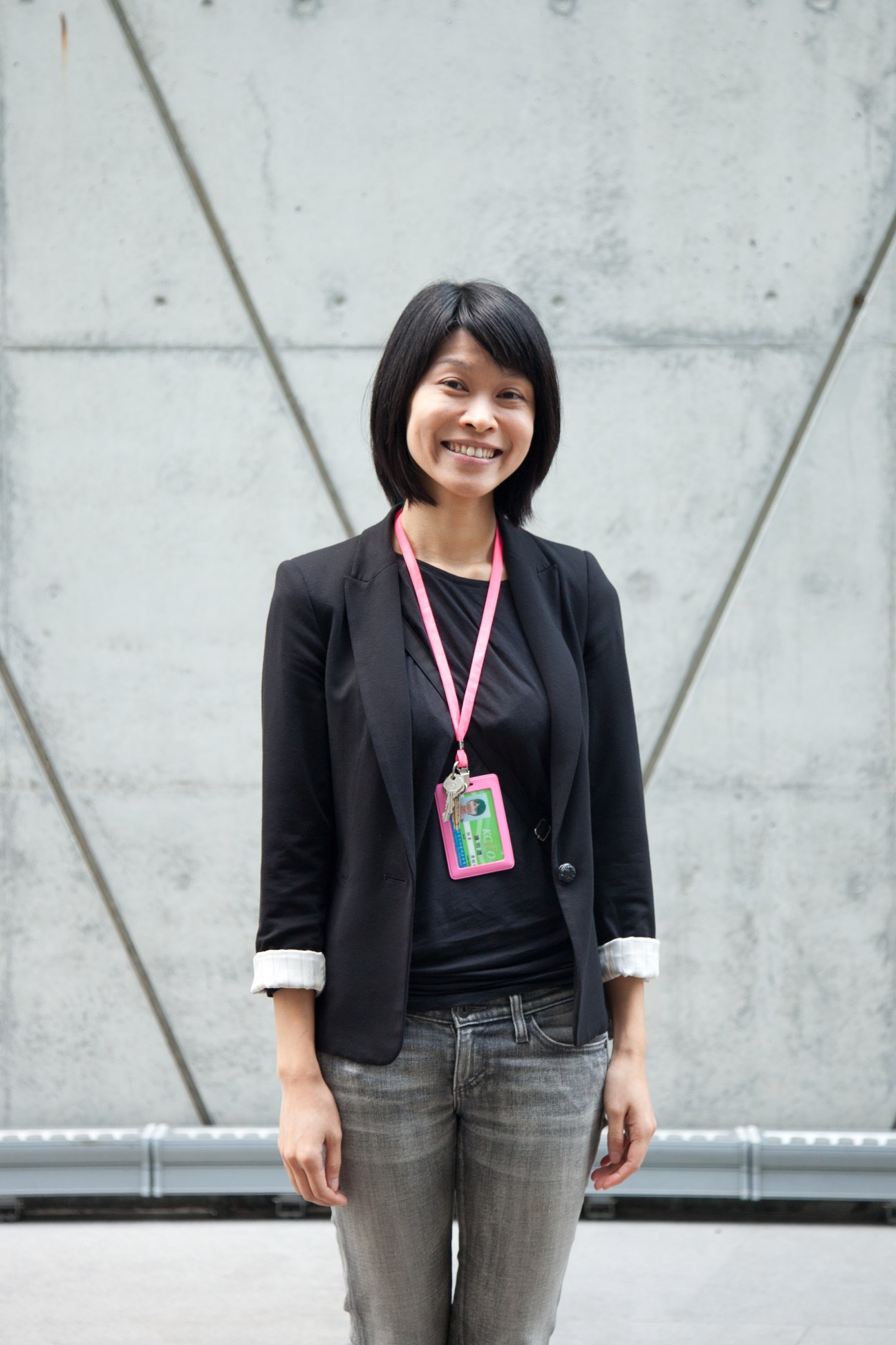 Julia Chan from Dadong Art Centre smiling in front of a concrete wall.