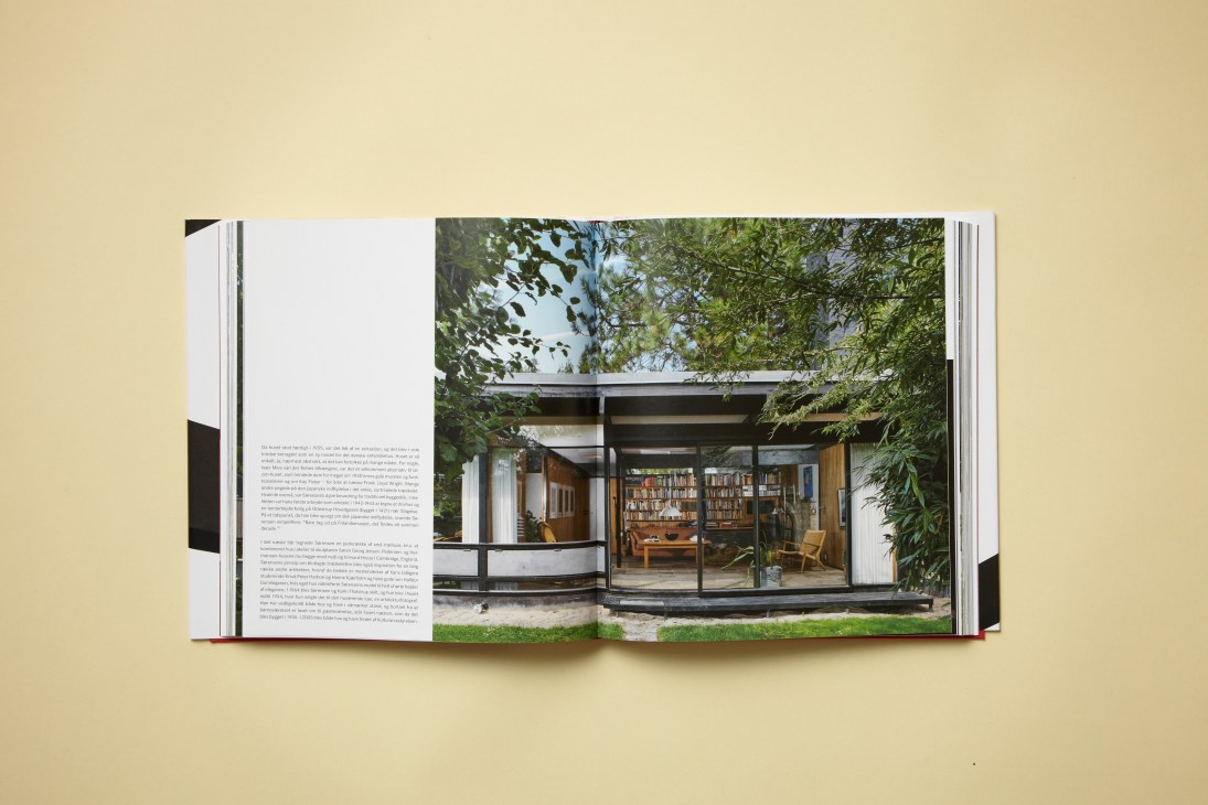 Open book showing Danish modernist residential architecture with glass doors and wooden interior visible.