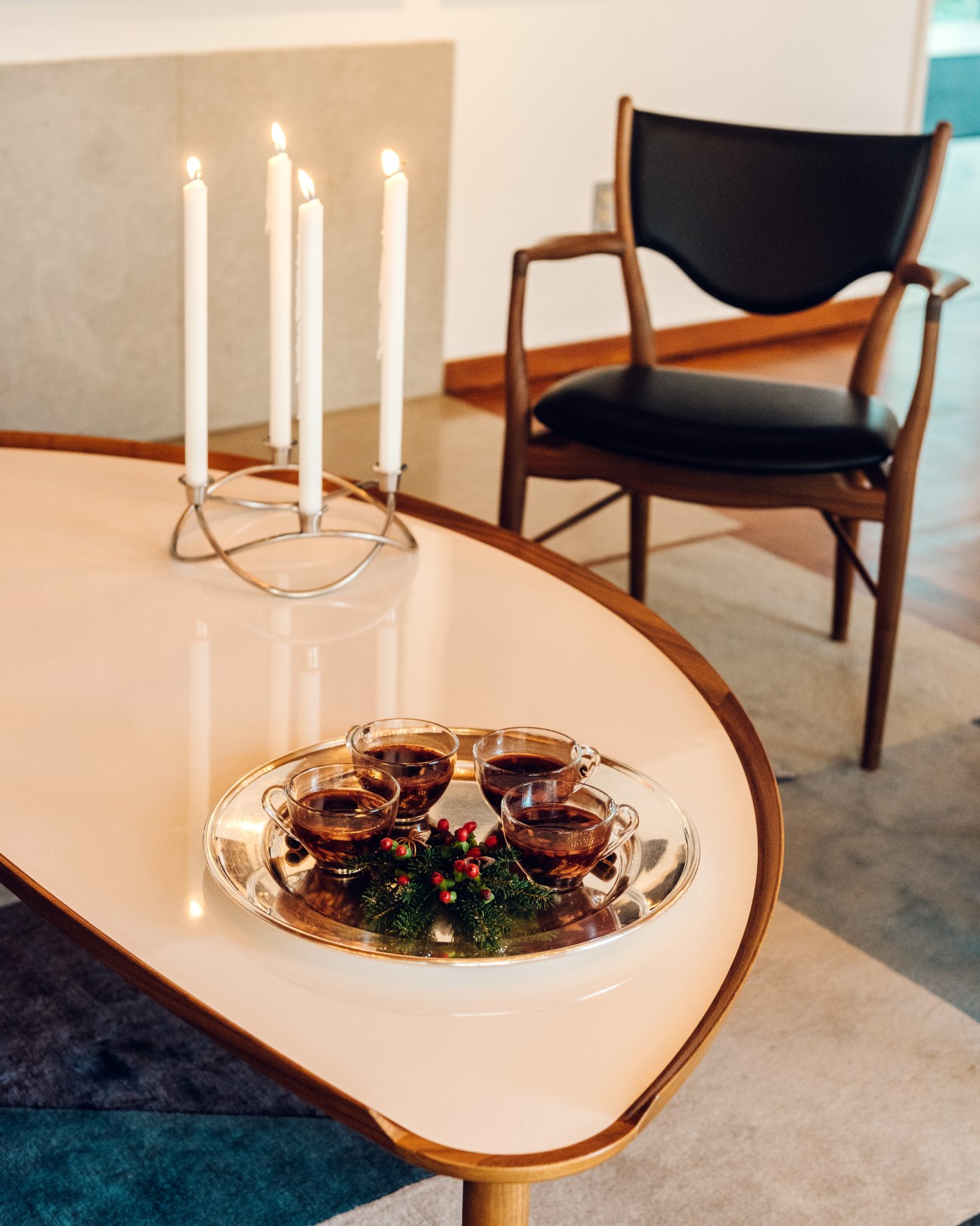 Four glasses of glogg mulled wine on a silver tray with greenery and berries at the Danish embassy.