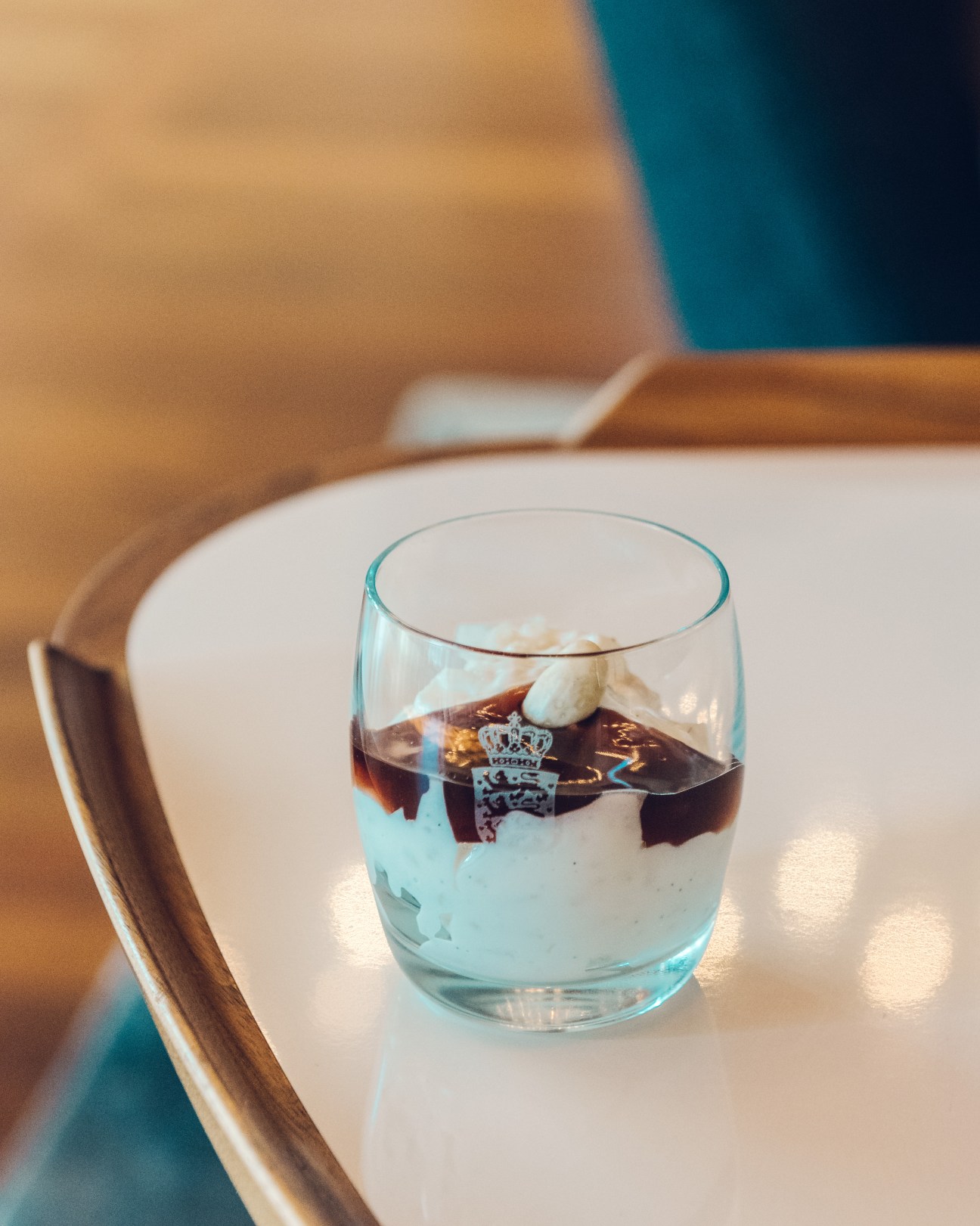 Glass of risalamande rice pudding with dark cherry sauce and whipped cream topping.
