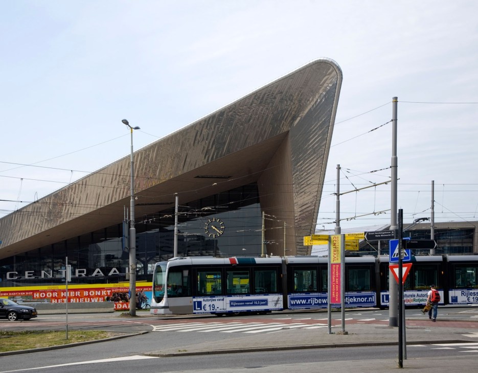 Rotterdam Centraal station with distinctive angular architecture and tram in foreground.