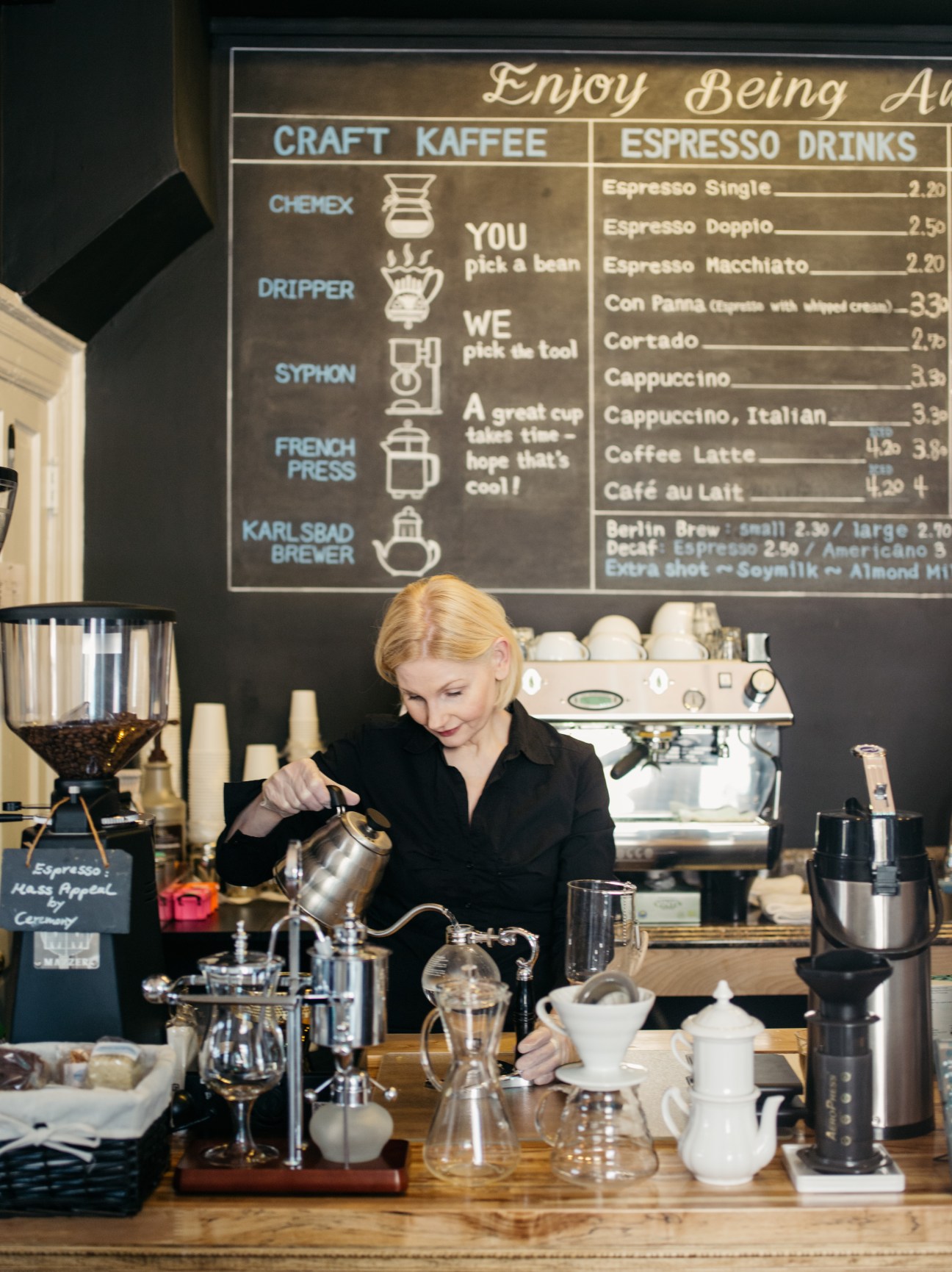 Woman barista pouring water from a kettle at a coffee bar in Washington, DC.