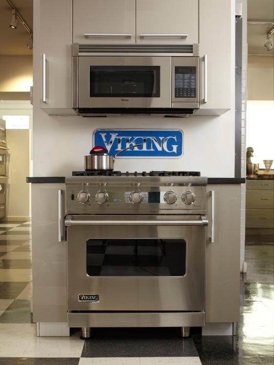 Viking stainless steel 30-inch dual-fuel range with microwave and blue Viking sign displayed in showroom kitchen.