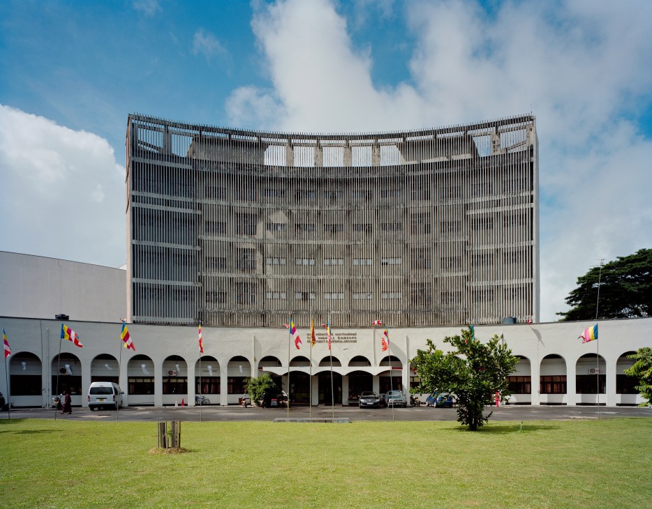 Department of National Archives building on Independent Square with white colonnade base and striped upper facade.