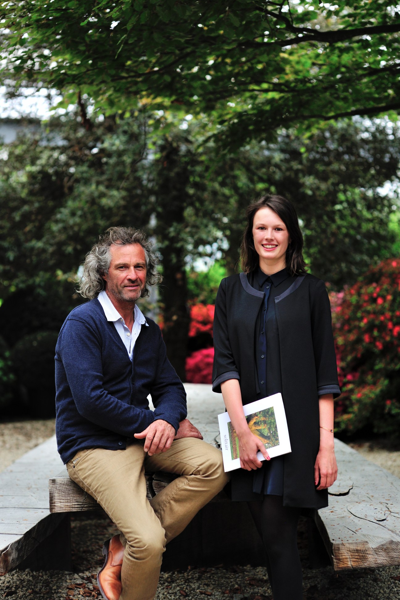 Dirk Cools and his daughter Chlöe pose together in a lush garden setting at the Solitair tree nursery.