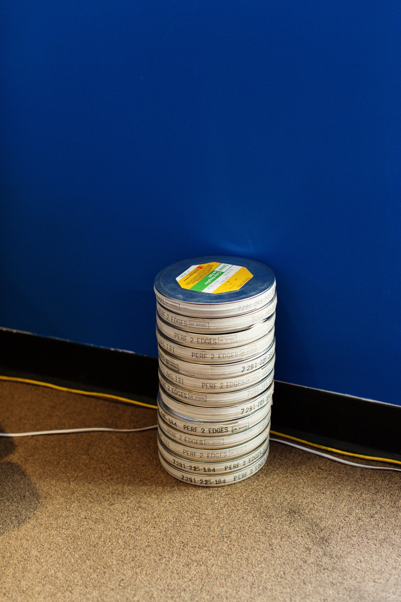 Stack of film reels with labels against a blue and black background.