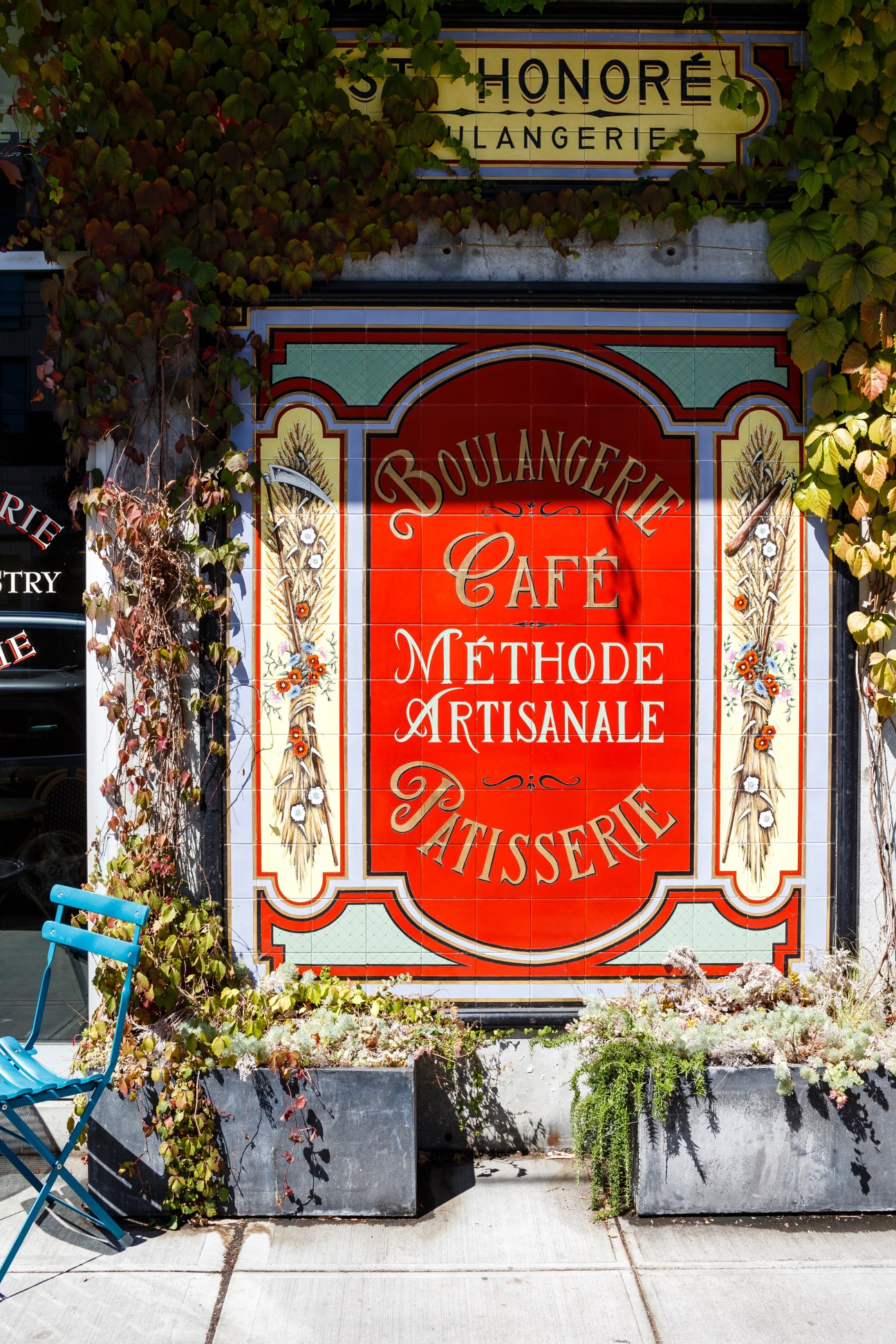 St Honoré Boulangerie storefront with ivy-covered facade and red tile signage on Division Street, Portland.