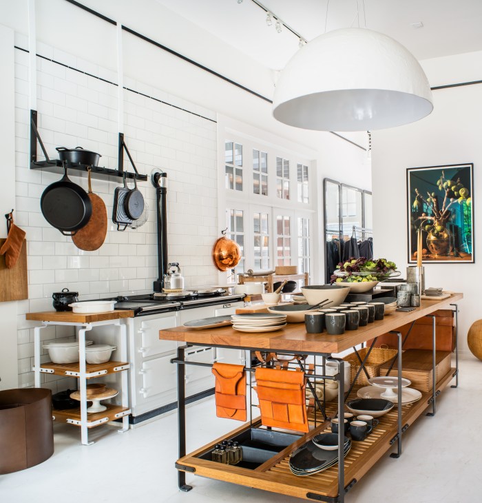 Interior of March design store in San Francisco with kitchen display featuring wooden tables, cast-iron cookware, and white subway tiles.