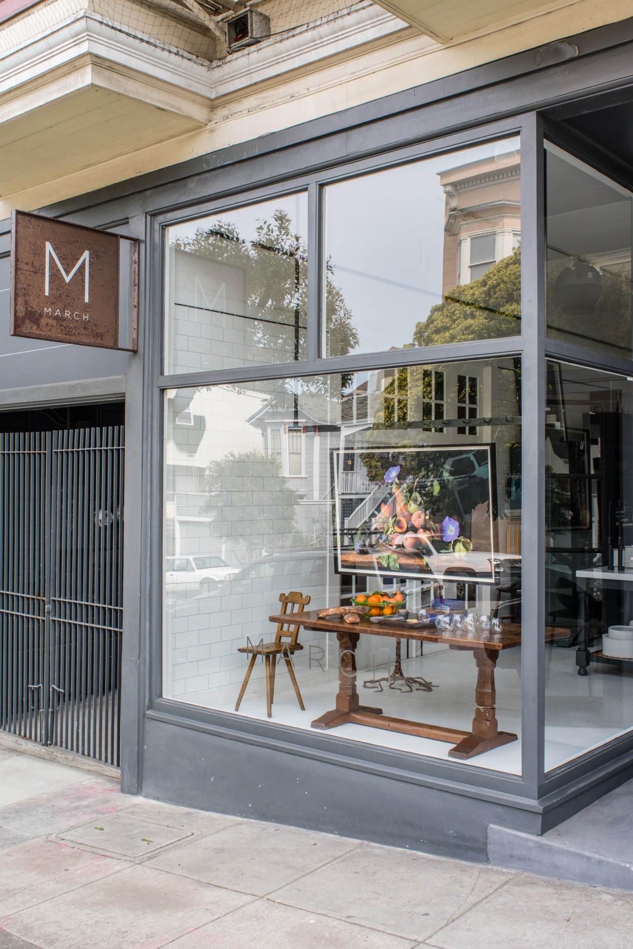Storefront of March design store in San Francisco with large windows displaying wooden furniture and kitchen items.