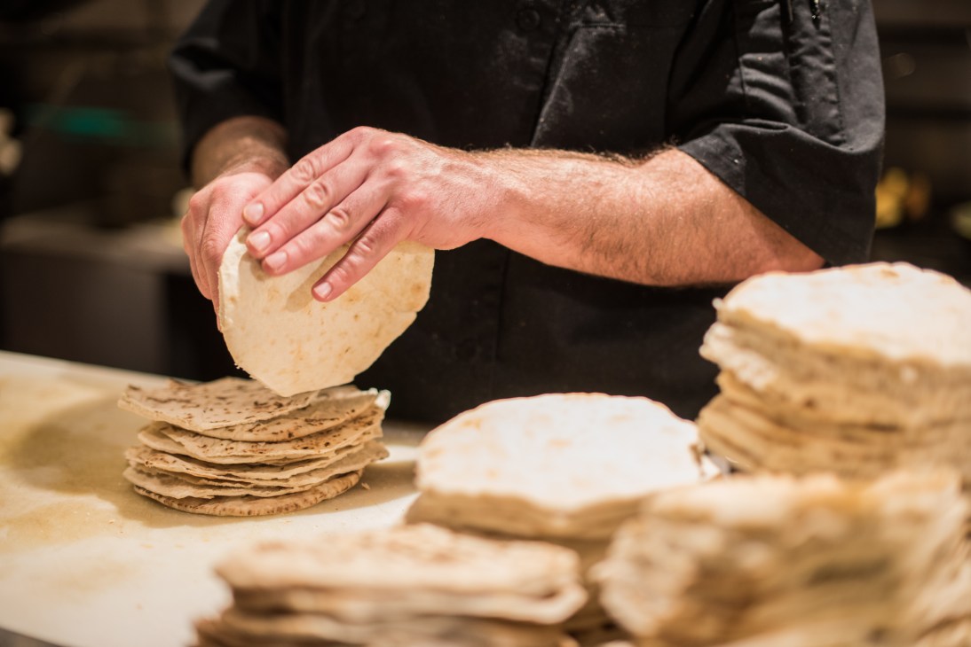 Chef's hands shaping pitta bread dough at Insalata's restaurant.