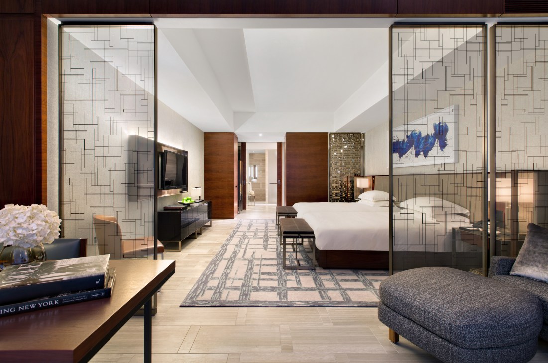 Modern hotel suite at Park Hyatt NYC with contemporary furnishings, wooden accents, and patterned glass partitions.