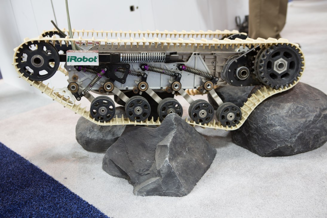 iRobot defense drone with tracked treads and mechanical components displayed on rocky surface