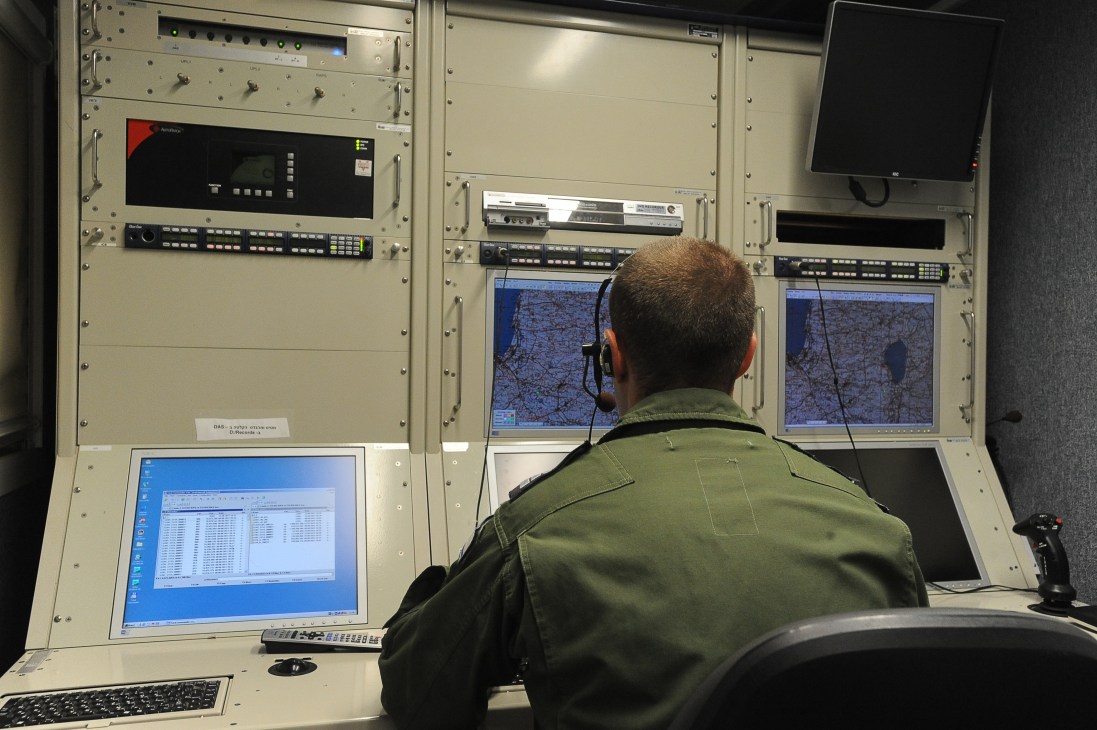 Israeli Air Force officer Captain Omer operates a UAV from a Ground Control Station, monitoring aerial feeds on multiple screens.