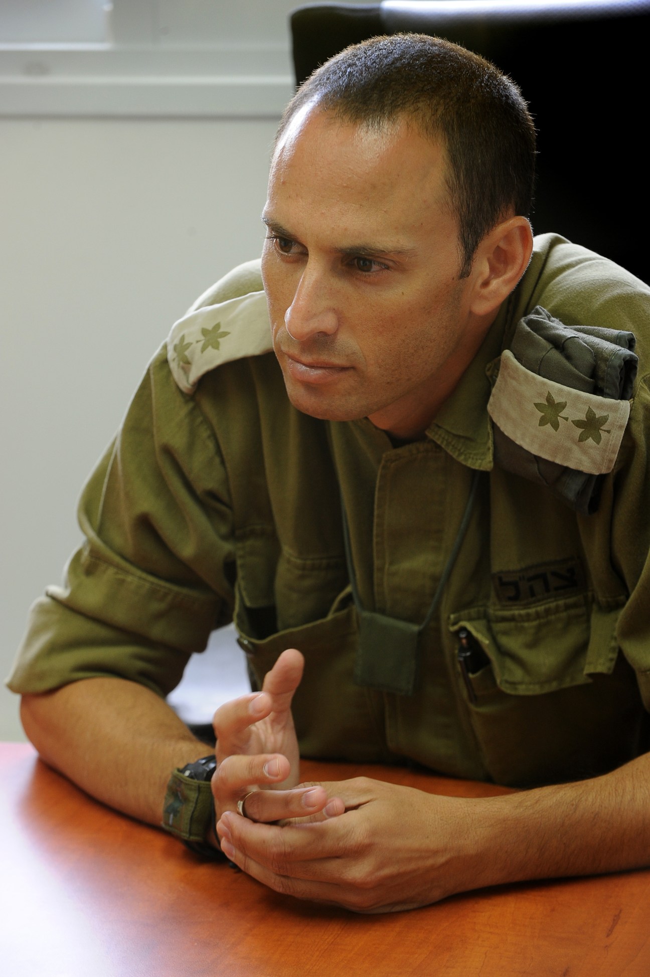 Lt Colonel Ori Gonen in military uniform gestures while speaking indoors