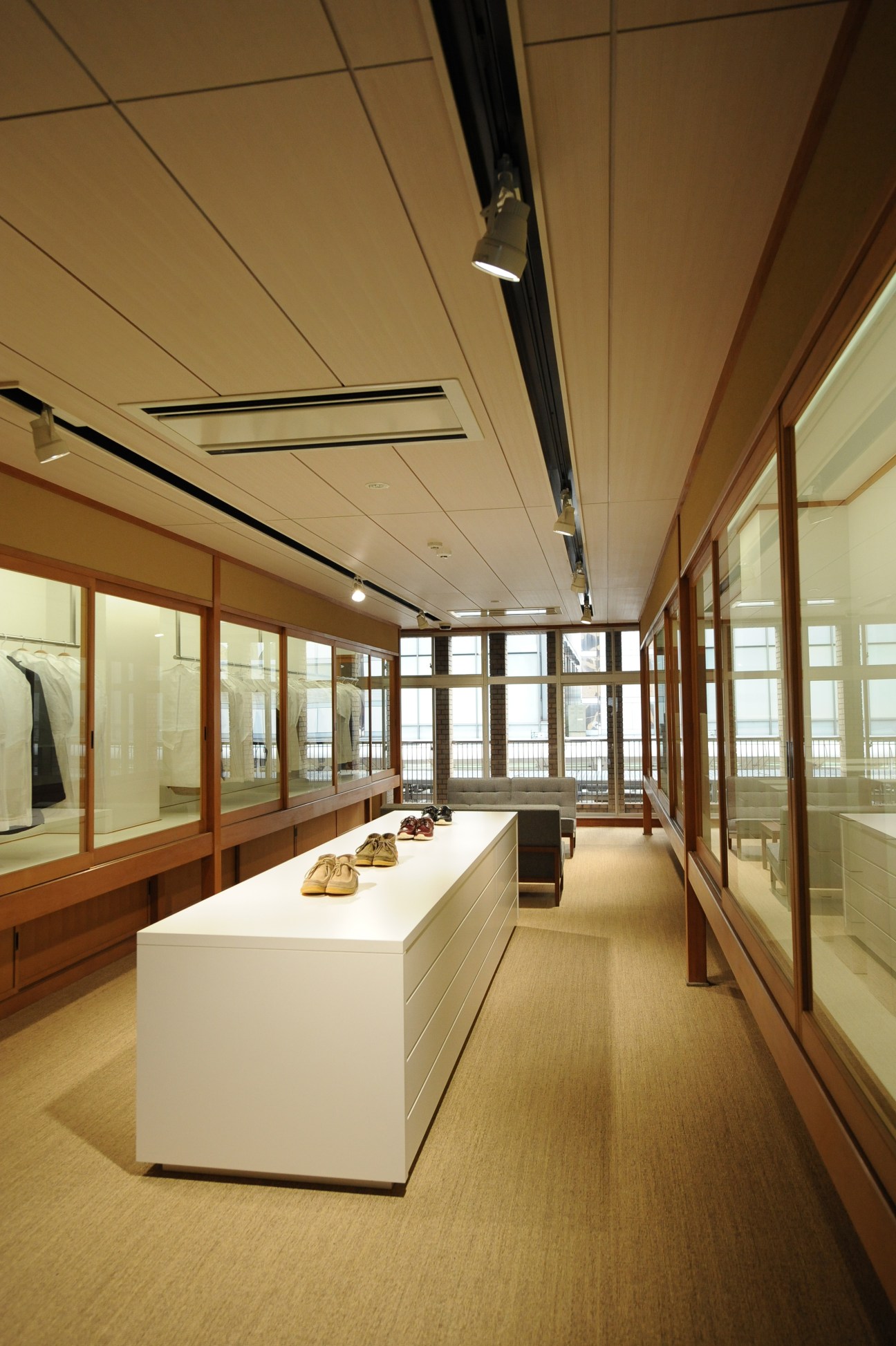Interior of Free International Laboratory retail store in Tokyo with wooden frames, white display counter, and shoes on display.