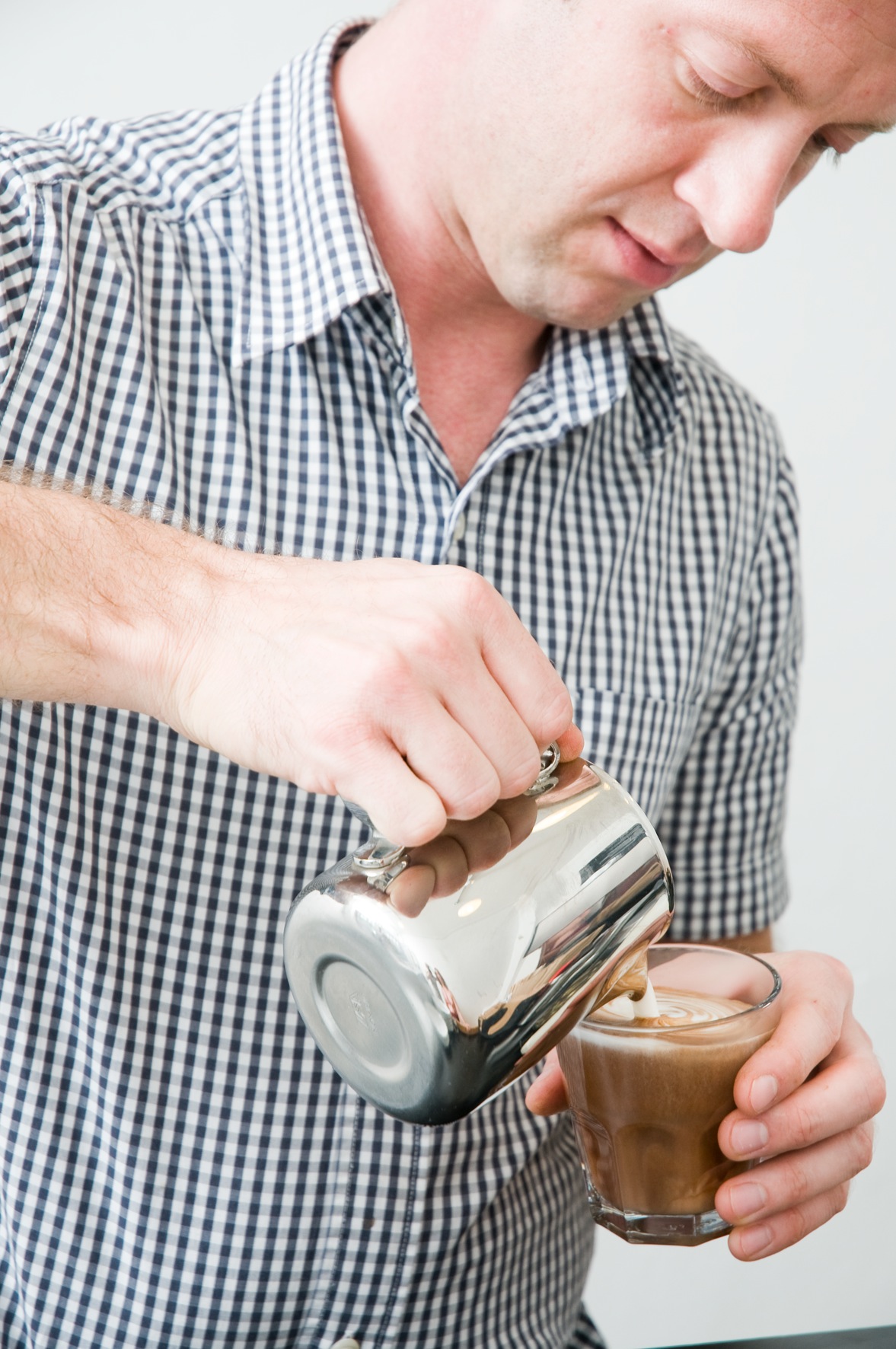 Ben Townsend pouring steamed milk into a coffee cup to create latte art.