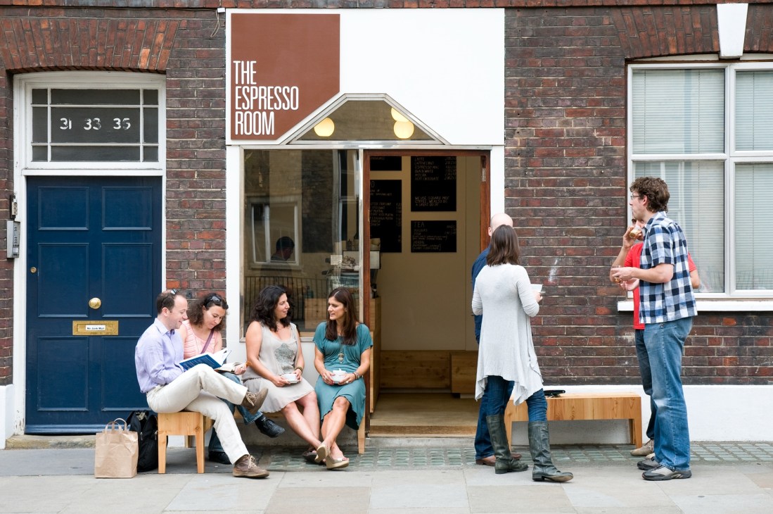 The Espresso Room storefront in Bloomsbury with customers sitting on benches outside the compact 1920s shop.
