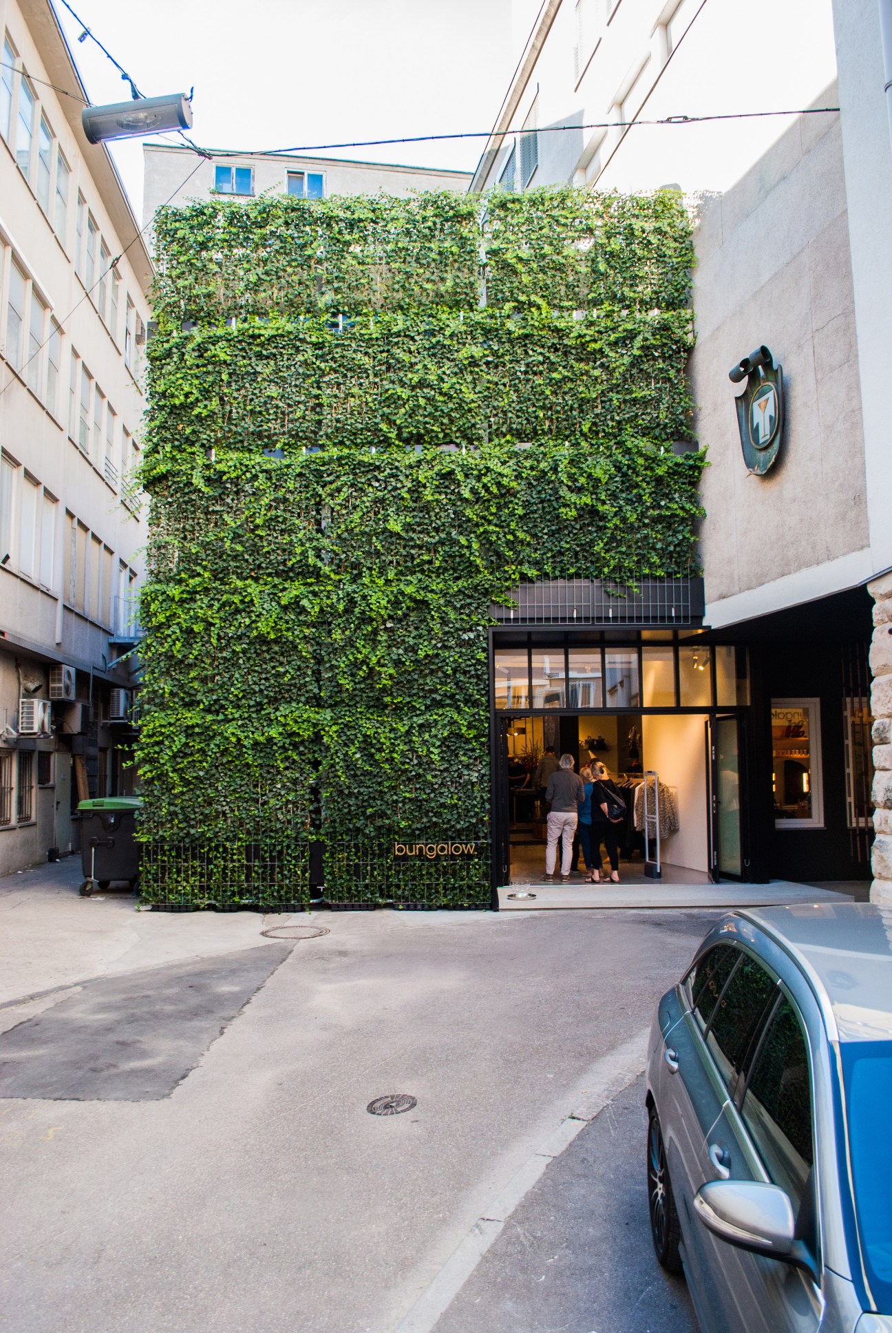 Bungalow menswear shop in Stuttgart with ivy-covered façade and black storefront entrance.