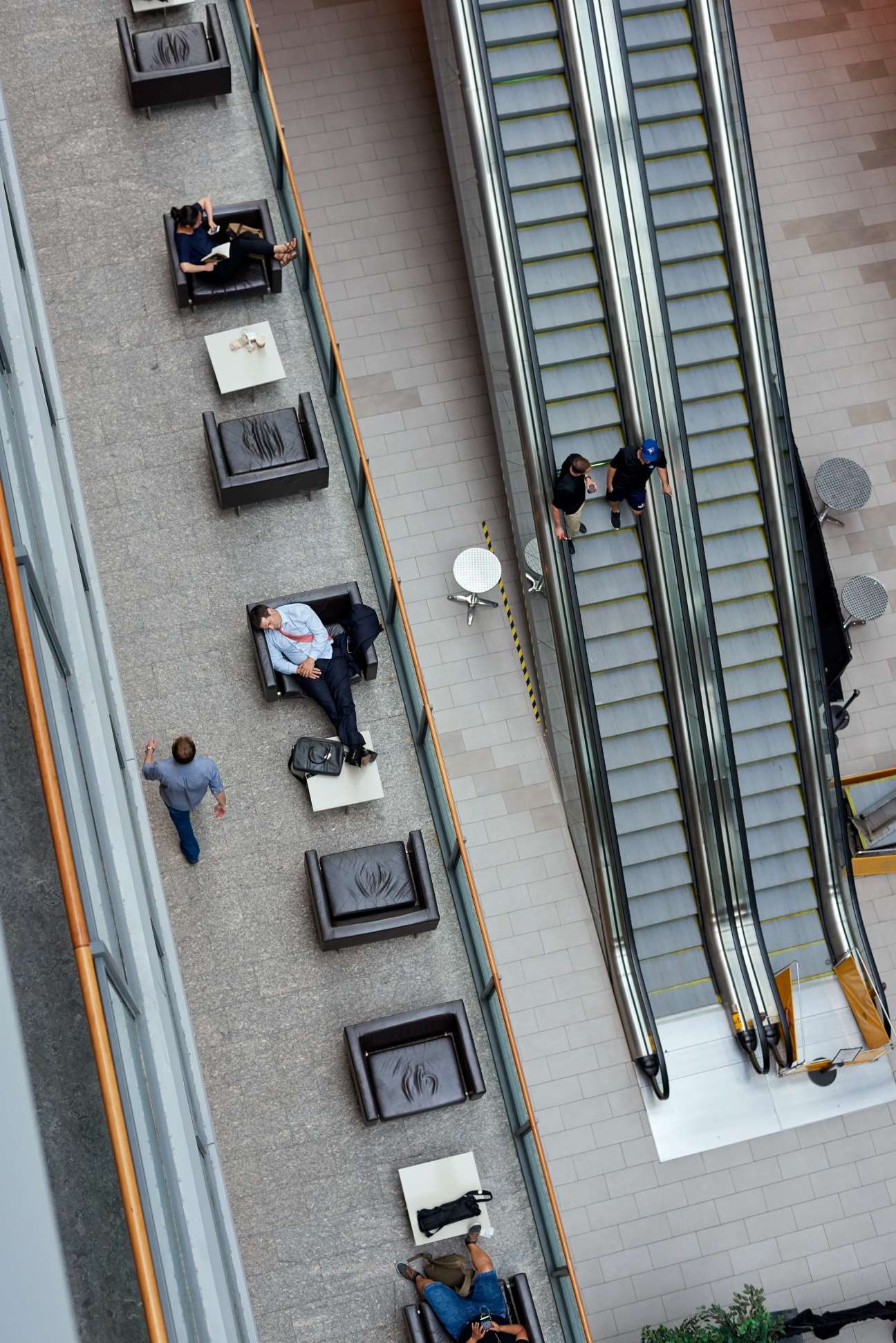 Overhead view of Mars Discovery District with people relaxing on black chairs near escalators.