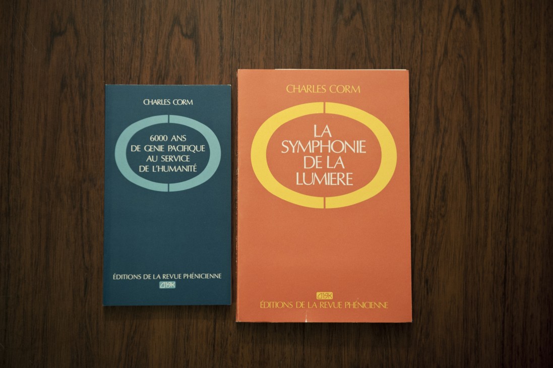 Two books by Charles Corm published by Editions de la Revue Phénicienne on wooden surface.