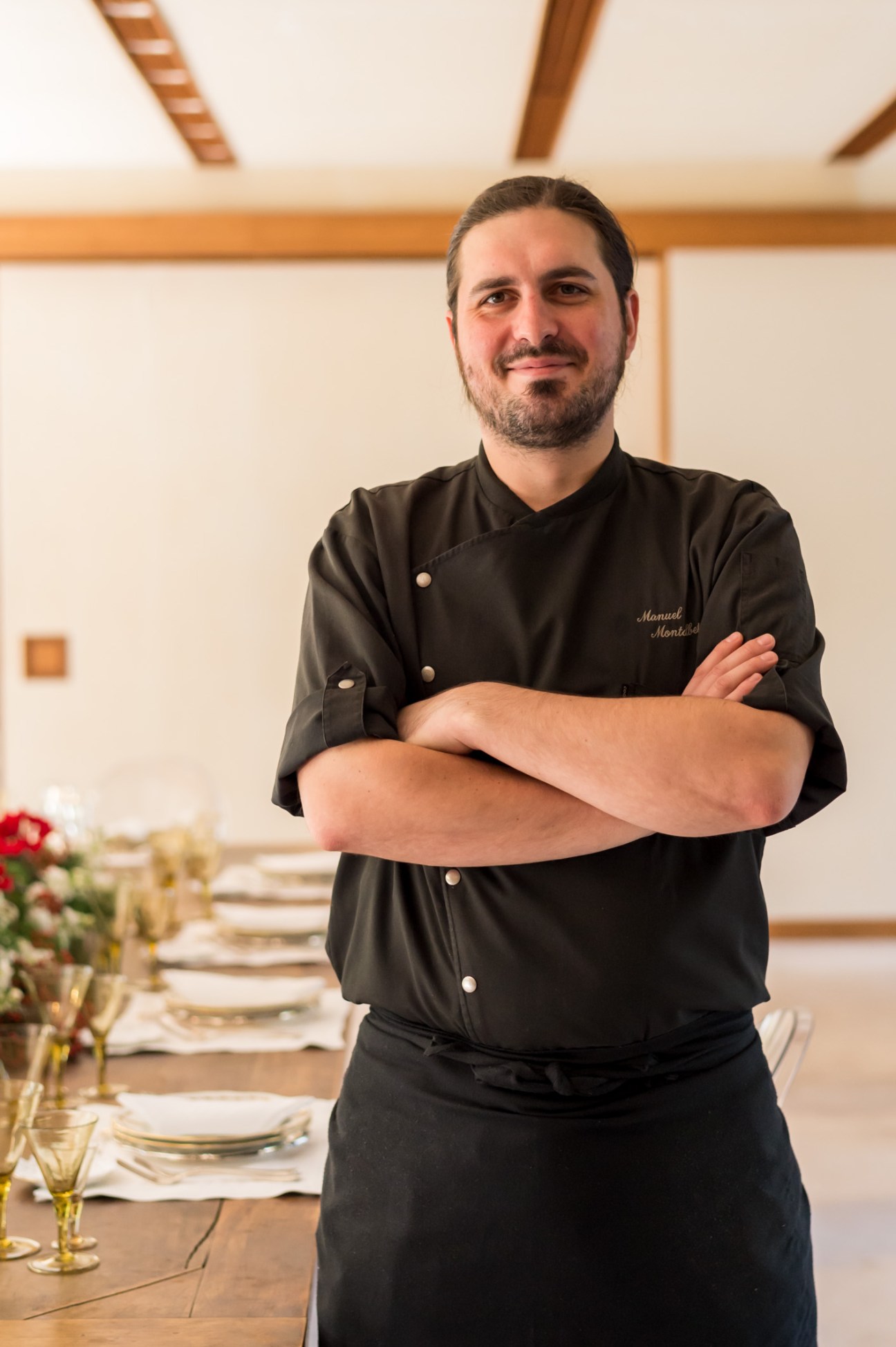 Head chef Manuel Montalbetti stands with crossed arms in a dining room at the Italian embassy in Tokyo.