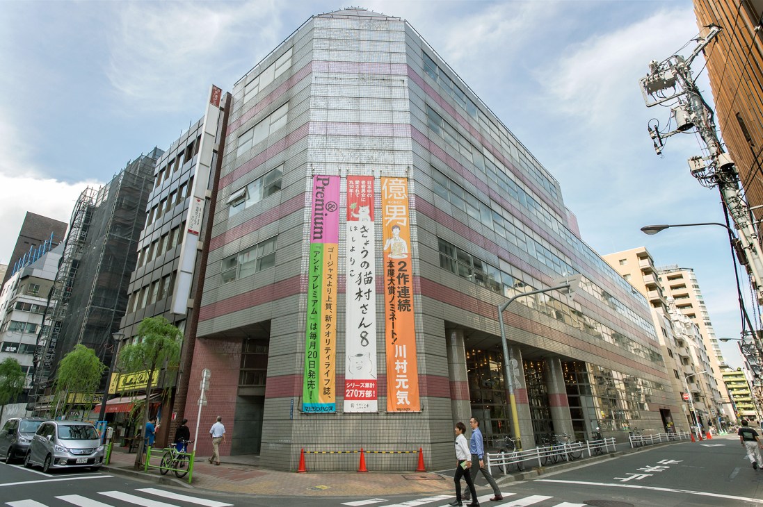Magazine House building in Higashi Ginza, Tokyo, with colorful Japanese banners displayed on its facade.