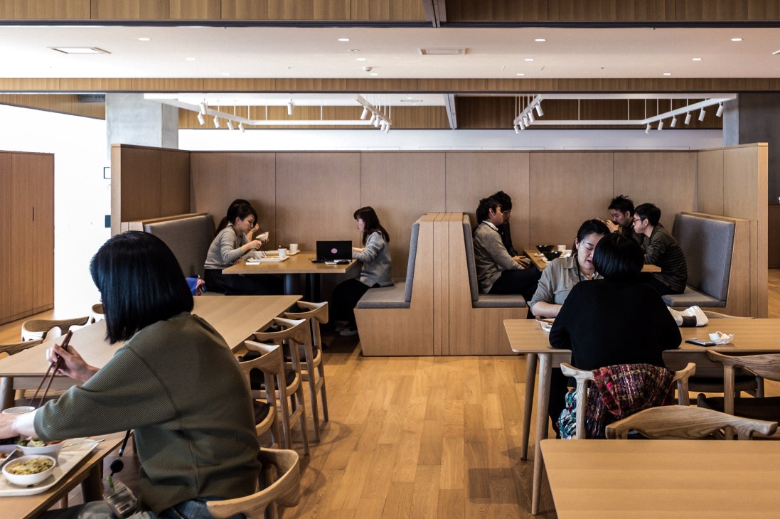 Uniqlo City's Daily Special canteen with wooden booths and tables where staff dine and socialize.
