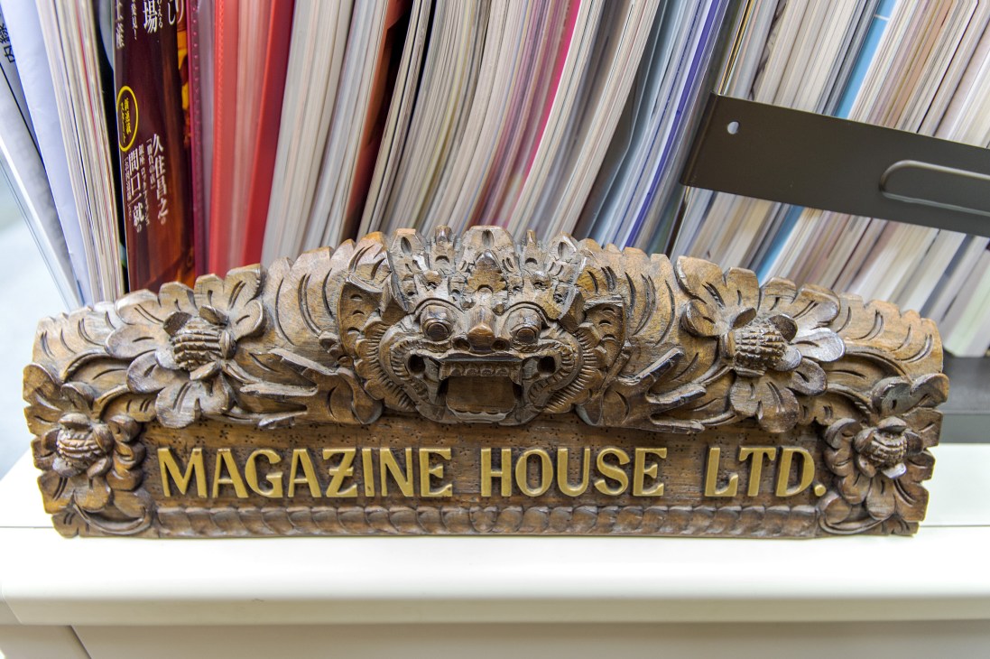 Ornate wooden carved plaque reading 'MAGAZINE HOUSE LTD' with decorative lion heads and floral motifs.