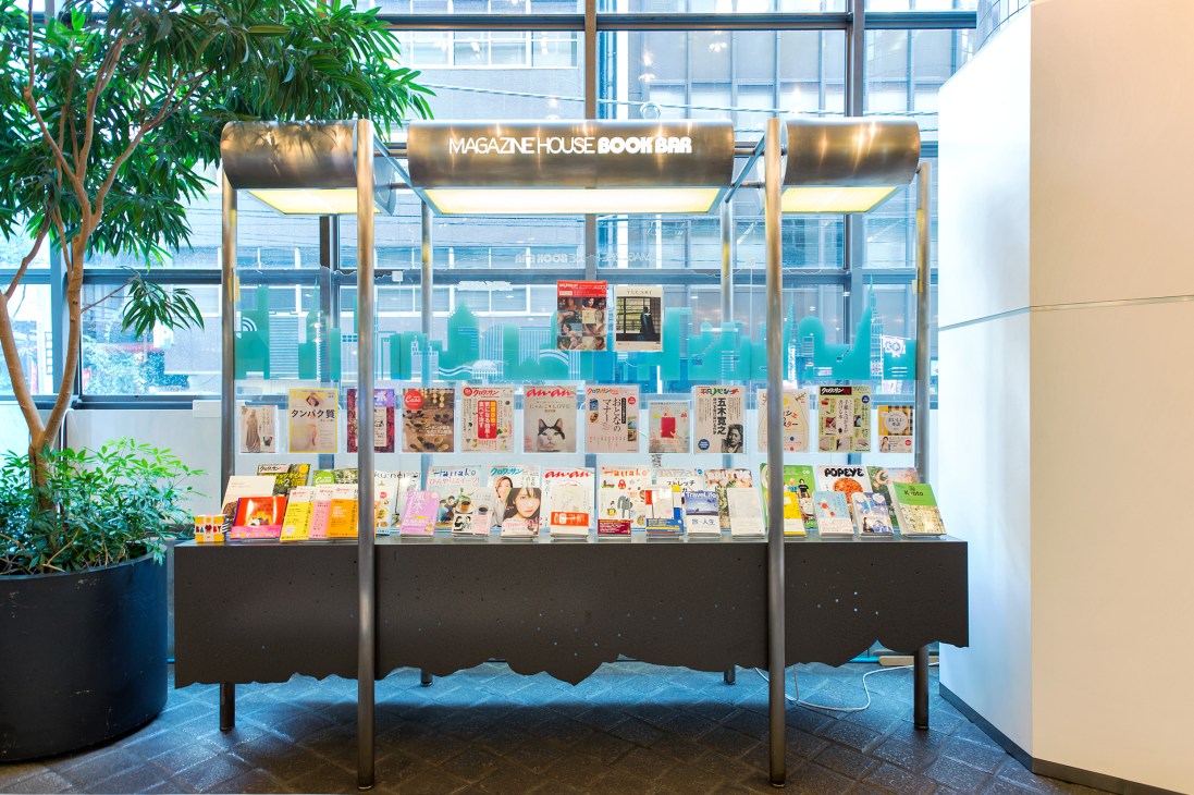 Magazine House Book Bar display window showcasing latest magazine issues with Tokyo cityscape visible through glass