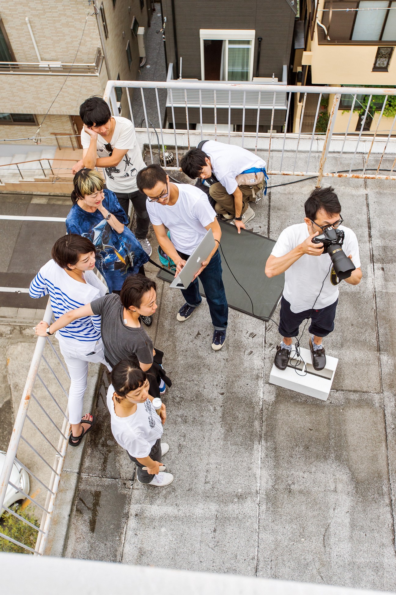 Photography team shooting on location for Ginza magazine, with model and crew on rooftop.