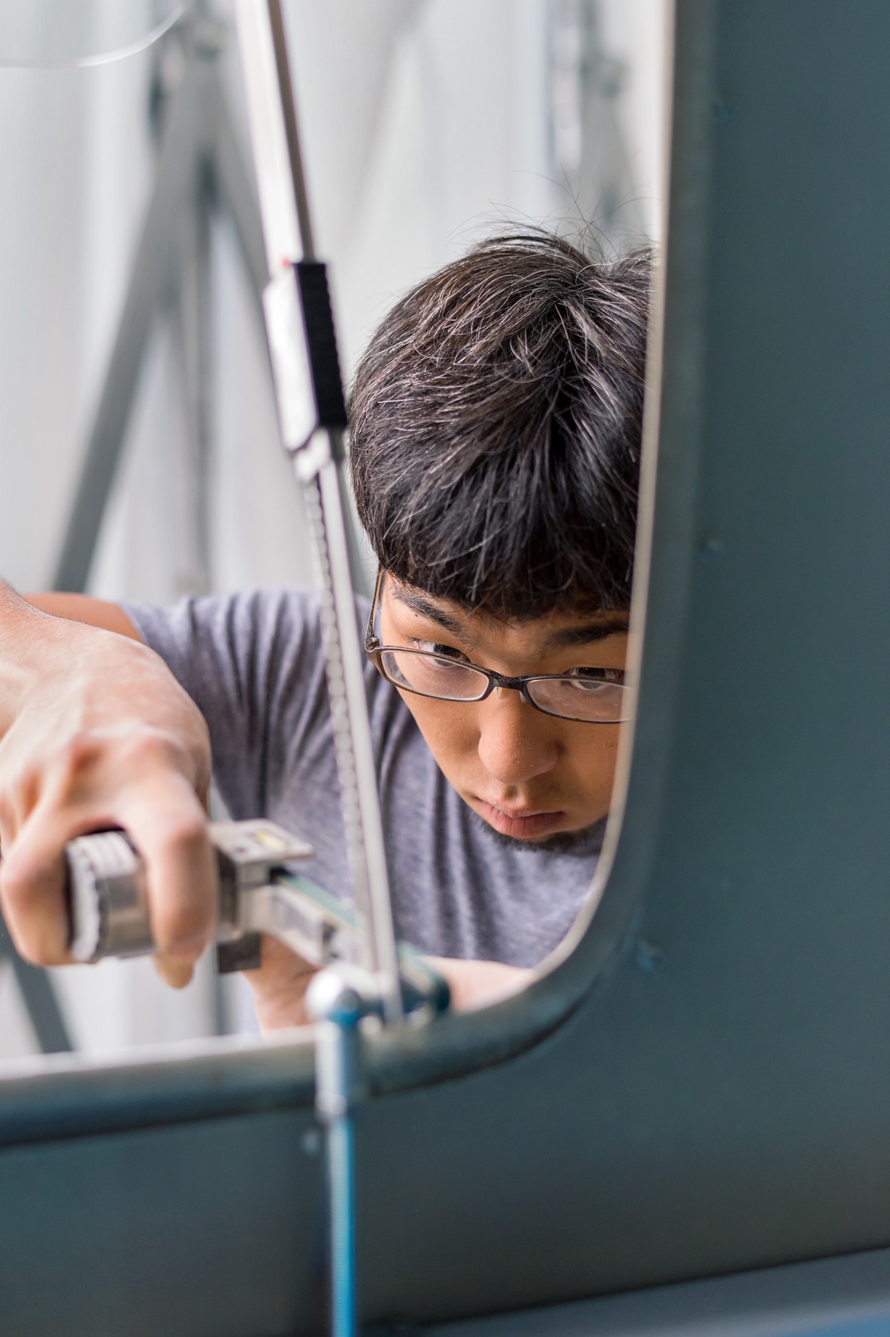 Person wearing glasses working on a curved component at Croco Art Factory in Sagamihara.
