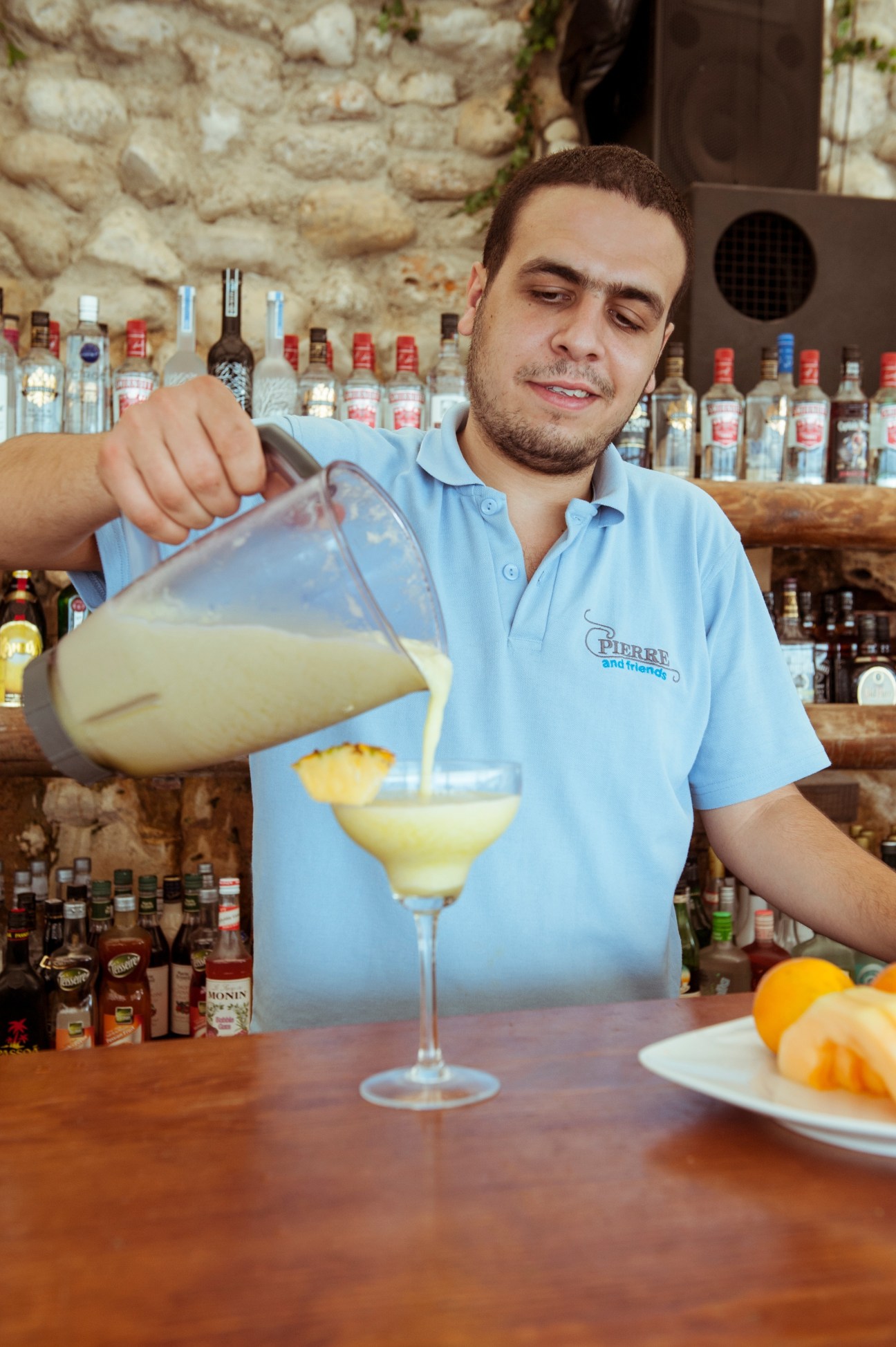 Bartender Ramy Abi Nader pouring a cocktail at Pierre and Friends beach bar in Batroun, Lebanon.