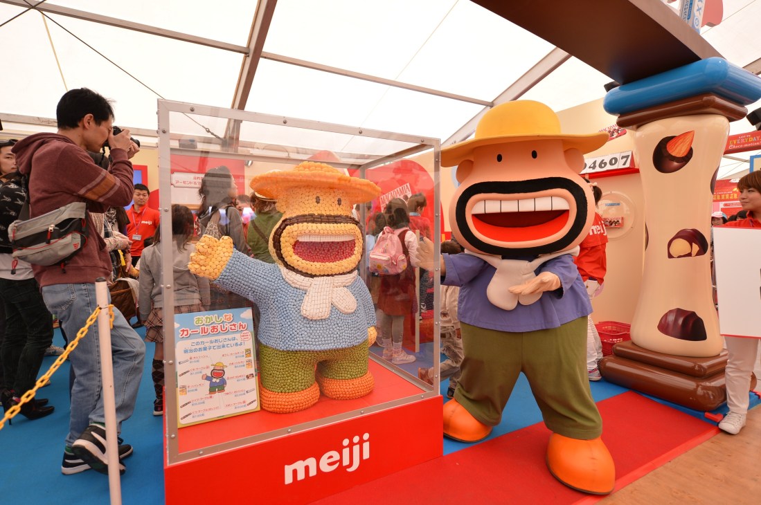 Meiji's Karl Ojisan mascot character displayed at the confectionery expo with visitors.