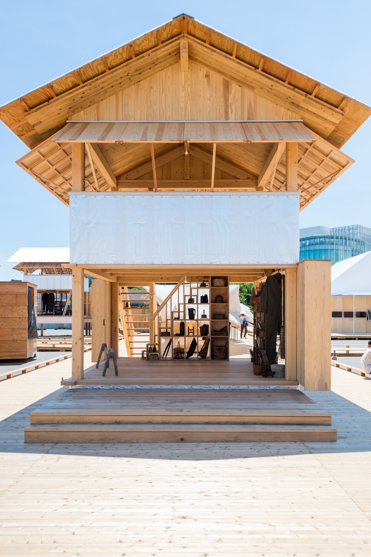 Wooden structure with open ground floor displaying shelving and staircase, designed as Tanada Terrace Office.