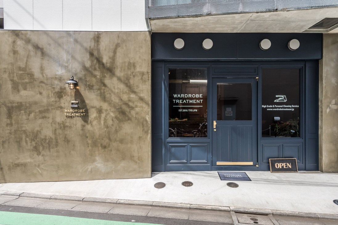Wardrobe Treatment storefront with dark blue doors and concrete facade on a Tokyo backstreet.