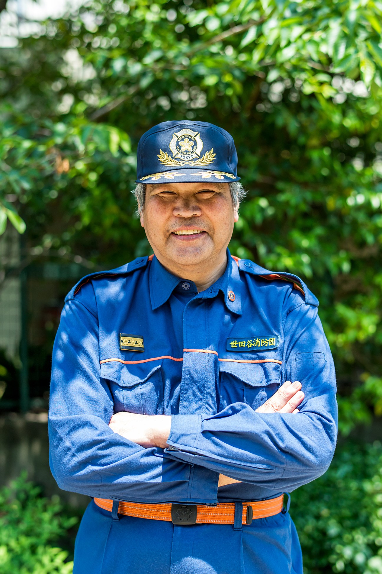 Masanori Kosaka, head of Tokyo's Setagaya Ward volunteer firefighter unit, wearing blue uniform and cap.