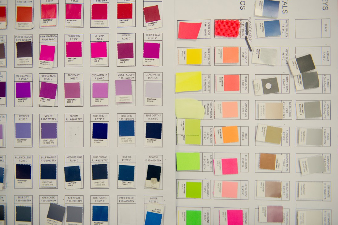 Pantone color swatches and fabric samples organized on a design board